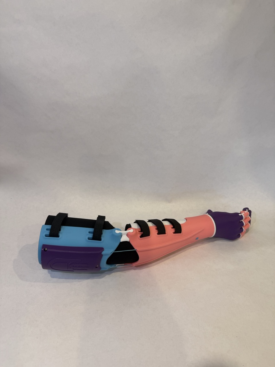 Complete Kinetic Arm — full assembly, blue socket, coral forearm, purple hand on clean background